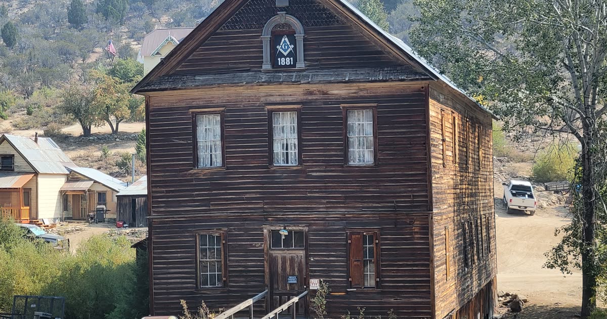 The historic Idaho Hotel and weathered wooden storefronts lining a dirt street in Silver City, Idaho